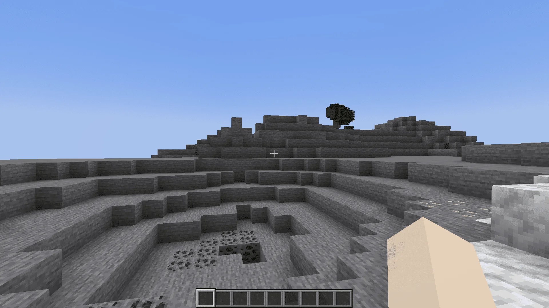 Player looks out over a large stone crater in a stony peaks biome