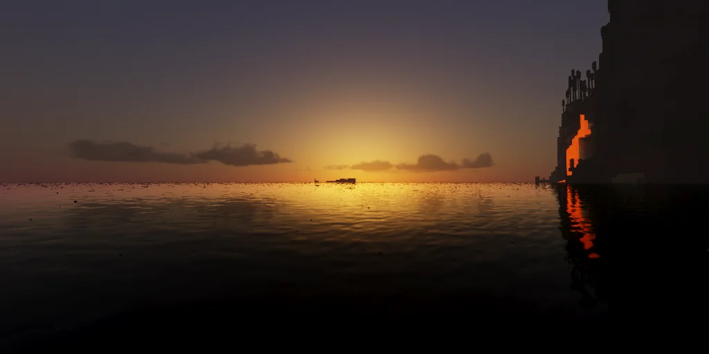 Sunset over calm ocean with a lava cascade glowing on the right-hand cliff